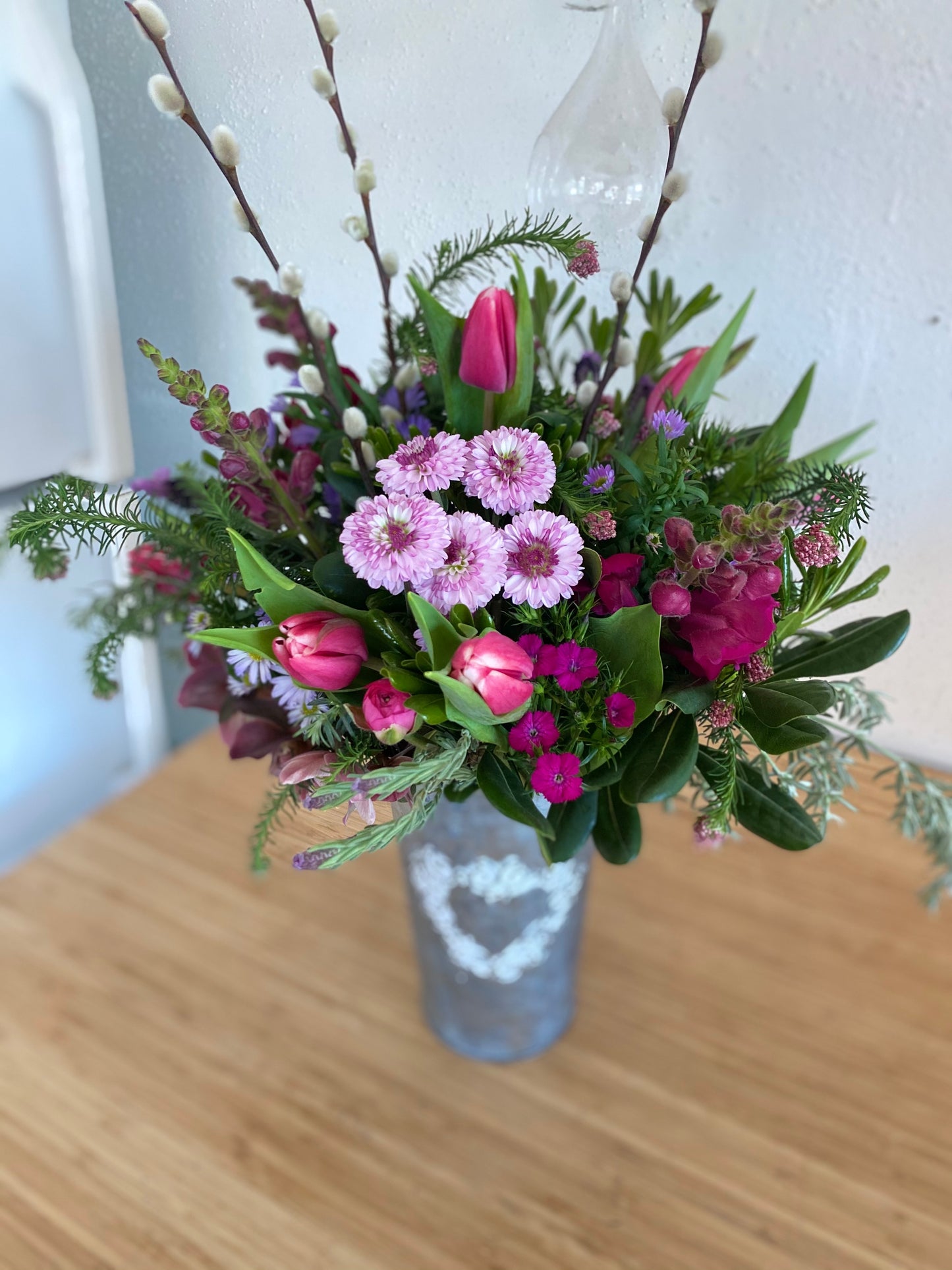 From my heart to yours in galvanized bucket with heart. locally sourced spring flowers in pinks and purples such as mums, snapdragons, tulips, lavender, rice flower, ranunculas. locally sourced flowers delivered in woodland, davis, esparto, knight's landing, valentines day flowers sustainable floristry in yolo county. woman owned small business
