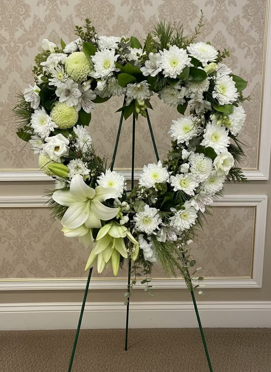 floral white and green heart wreath with a natural park background