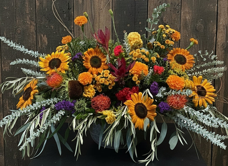 Colorful flower arrangement on a wooden table with a blurred background sarah larkin design
